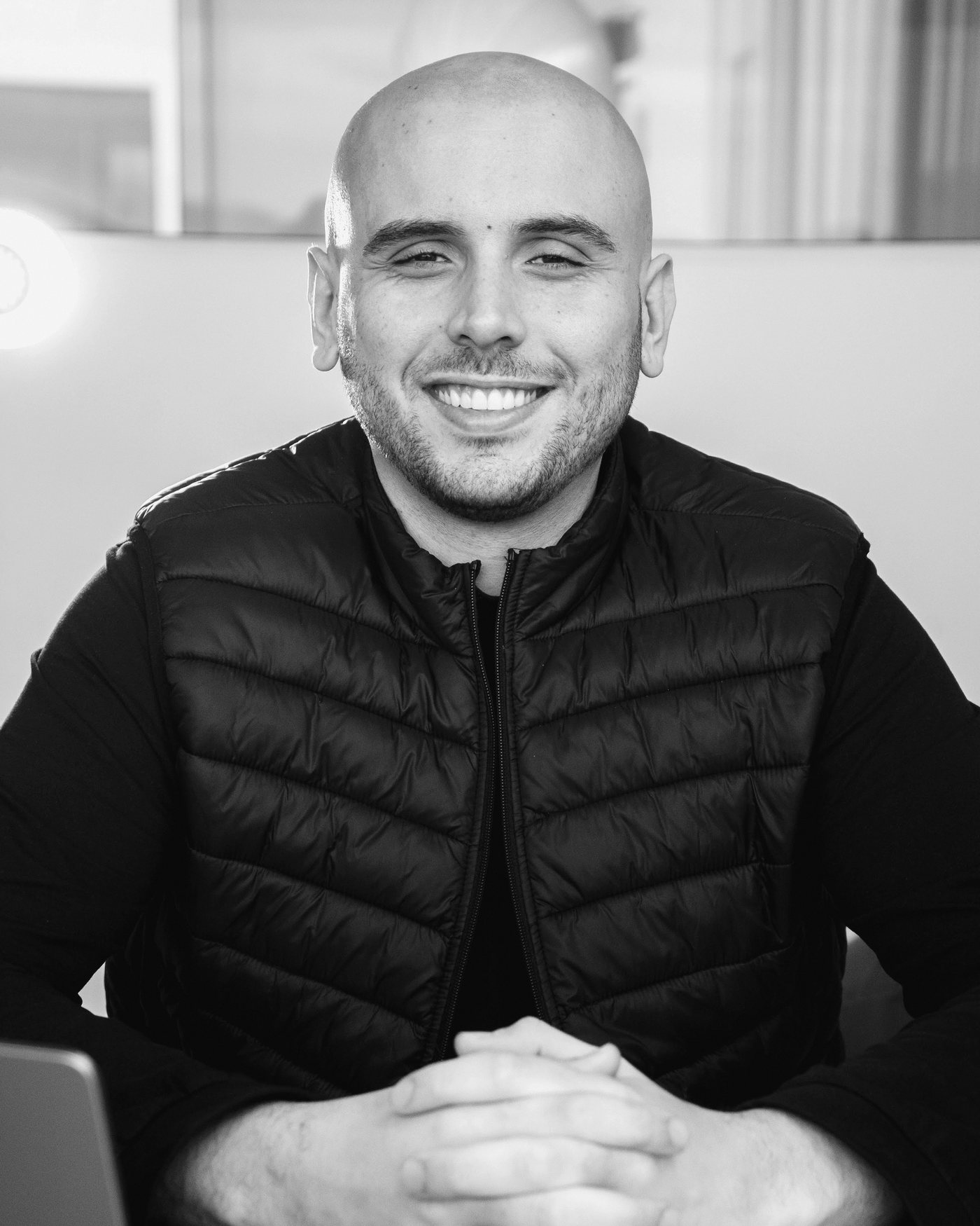 Hélio Costa Jr. sorrindo, sentado à mesa